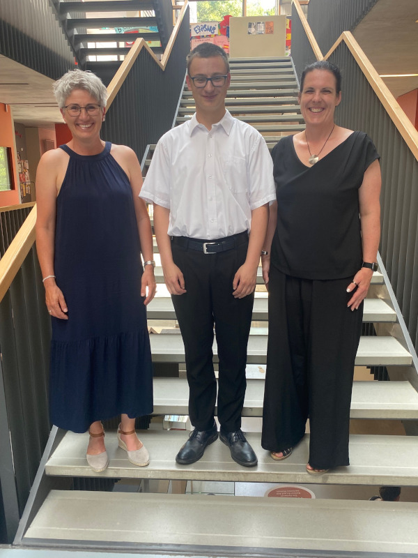 Bankkaufmann Shayan Täuber mit den Klassenlehrerinnen Bianca Müller-Gillhart und Maren Trojan 